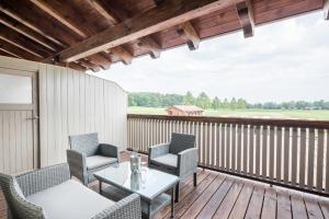 a patio with chairs and a table on a deck at Seehof am Waginger See in Petting