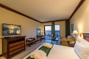 a bedroom with a bed and a living room at Grand Hotel Gozo in Għajnsielem