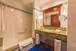 a bathroom with a tub and a sink and a shower at Grand Hotel Gozo in Għajnsielem