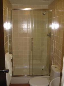 uma casa de banho com um chuveiro, um WC e um lavatório. em The Langham Hotel em Northampton