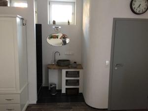 a small bathroom with a sink and a mirror at Ferienwohnung Freiburg und March in Holzhausen