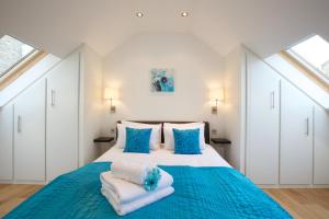 a bedroom with a large bed with towels on it at Miles Place by Viridian Apartments in London