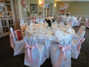 une salle de banquet avec des tables et des chaises blanches avec des arches roses dans l'établissement Grand Palms Spa & Golf Resort, à Pembroke Pines 37 autres photos