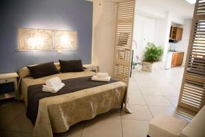 een slaapkamer met een bed met twee handdoeken erop bij Villa Di Giorgi Apartments in Cefalù