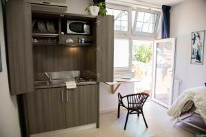 a kitchen with a sink and a chair in a room at Villa Di Giorgi Apartments in Cefalù