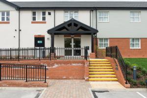 una casa con una puerta negra y escaleras delante en Kings Chamber, Doncaster by Marston's Inns, en Doncaster