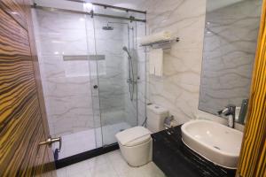 uma casa de banho com um chuveiro, um WC e um lavatório. em Sun Star Grand Hotel em Manila