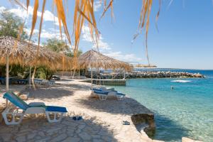a beach with a bunch of chairs and the water at Holiday Park Mandrice in Mandre