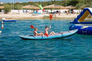 two girls are riding on a raft in the water at Holiday Park Mandrice in Mandre