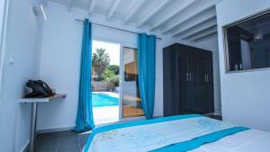 a bedroom with a bed and a view of a swimming pool at Villa Elpiniki in Ixia +57 photos