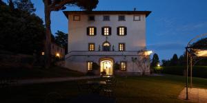 a large white building with its lights on at night at Borgo Il Castagno in Gambassi Terme