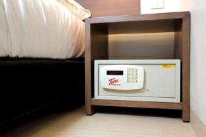 a microwave in a cabinet next to a bed at Tune Hotel – Kota Bharu City Centre in Kota Bharu