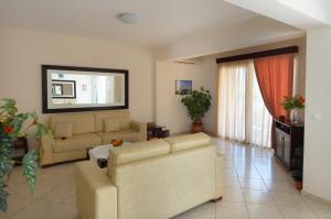 a living room with two couches and a couch at Hotel Liberty in Chrysi Ammoudia