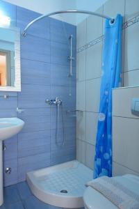 a bathroom with a shower with a toilet and a sink at Hotel Liberty in Chrysi Ammoudia +49 photos