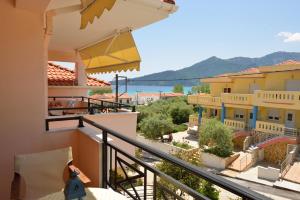 a woman standing on a balcony looking at the view from a house at Hotel Liberty in Chrysi Ammoudia