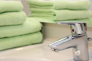umywalkę z kranem obok ręczników w obiekcie Apartment Warmuth w mieście Tröpolach