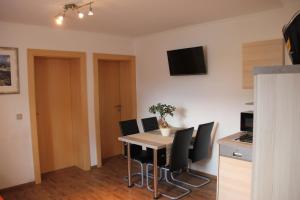 une salle à manger avec une table et des chaises noires dans l'établissement Apartment Warmuth, à Tröpolach