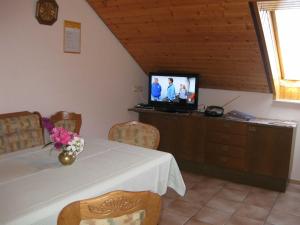 a dining room with a table and a television at Haus Rehblick in Bräunlingen