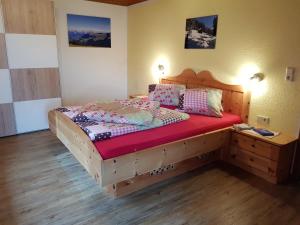 Schlafzimmer mit einem Holzbett mit einem Kopfteil aus Holz in der Unterkunft Haus Margret in Stummerberg