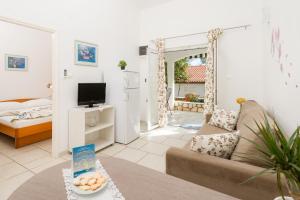 a living room with a couch and a tv at Holiday Park Mandrice in Mandre