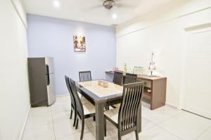 a dining room with a table and chairs and a refrigerator at My Jonker Homes in Melaka