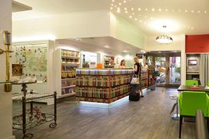 a woman standing in a store with a book shelf at Park Hotel Post in Freiburg im Breisgau