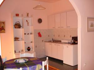 a kitchen with white cabinets and a table in a room at Apartments Ivna Bilek in Opatija