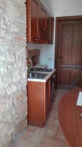 cocina con pared de piedra y fregadero en Agriturismo Cerquaglia, en Todi
