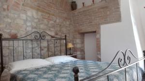 - une chambre avec un lit et un mur en briques dans l'établissement Agriturismo Cerquaglia, à Todi