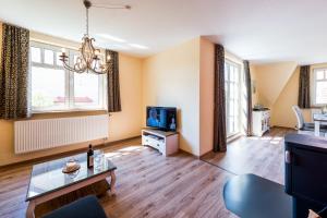 a living room with a couch and a tv at Bellevue Ferienwohnungen in Quedlinburg