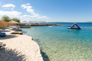 a beach with chairs and umbrellas and the water at Holiday Park Mandrice in Mandre