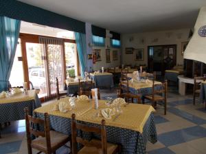 ein Restaurant mit Tischen und Stühlen sowie gelben Tischdecken in der Unterkunft Hotel Maremonti in Vico del Gargano