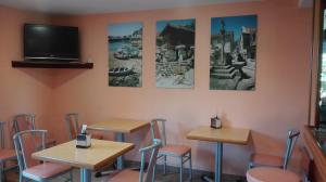 a restaurant with tables and chairs and a tv on the wall at Pension Pilar in Sanxenxo