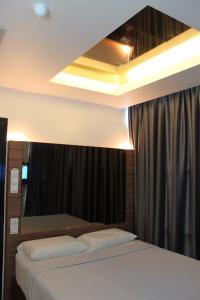 a bedroom with a bed and a black curtain at Dream Hotel in Klang