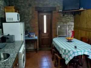 a small kitchen with a table and a refrigerator at Callejon de la Vega in Ríocaliente