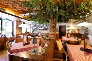 a restaurant with a tree in the middle of the room at Landgasthof Hotel Pröll in Eichstätt