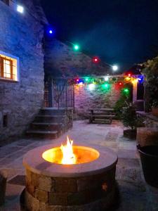 eine Feuerstelle mitten auf einer Terrasse in der Nacht in der Unterkunft Rustici Maggia in Aurigeno