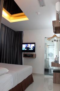 a bedroom with a bed and a tv on a wall at Dream Hotel in Klang