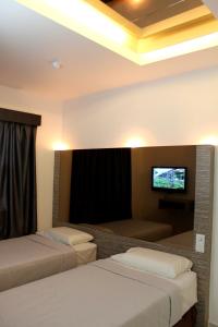 a hotel room with two beds and a flat screen tv at Dream Hotel in Klang