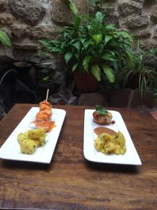 dos platos blancos de comida en una mesa de madera en Hostal Emilia, en Trujillo