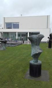a statue in the grass in front of a building at B&B Het Museum in Berlaar