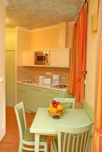 a kitchen with a table with a bowl of fruit on it at Hotel Kalma in Hévíz