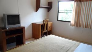 a living room with a tv and a window at Bautong Lodge in Chiang Mai