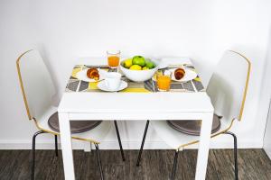 a white table with a bowl of fruit on it at Apartment Be My Guest in Zagreb