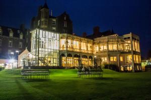 a large building with benches in front of it at night at Crieff Hydro in Crieff
