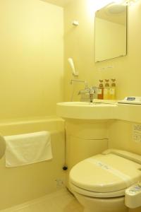 
a white toilet sitting next to a white sink at Hotel Union in Kagoshima
