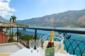 a bottle of wine sitting on a table with wine glasses at Guesthouse Grotta Di Nicola in Kotor