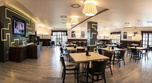 a dining room with tables and chairs in a restaurant at Hotel Fox in Wolbórz