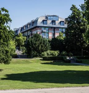 ein großes Gebäude mit vielen Bäumen davor in der Unterkunft SEEhotel Friedrichshafen in Friedrichshafen