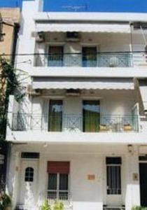 un edificio bianco con finestre e balcone di Helios&Thalassa Rooms a Loutra Edipsou